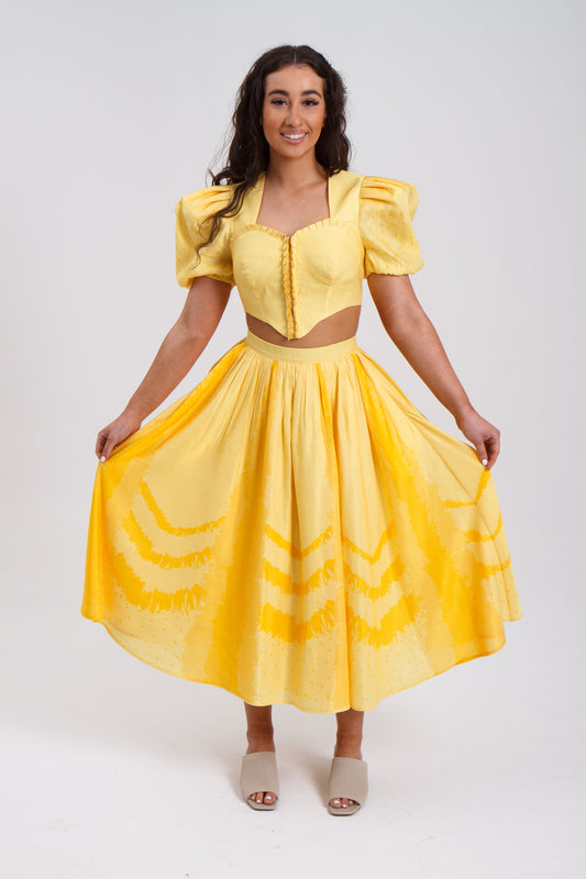 PRODUCT DESCRIPTION   Premium silk cotton linen, Daffodil-Yellow unique 2-piece midi dress with short puff sleeves exclusive to MAZASHIE.  Sweetheart neck, crop top with shirred back and bra-cut detail.  Placement prints on the voluminous skirt and polka-dotted puff sleeves.  The elasticated skirt waistband makes a perfect fit.  The shirred back band makes a perfect fit.  Invisible back zip closure at skirt.  Side seam concealed pockets.  Hooks and eyes closure at front.